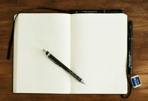 A pen lying on an open blank notebook